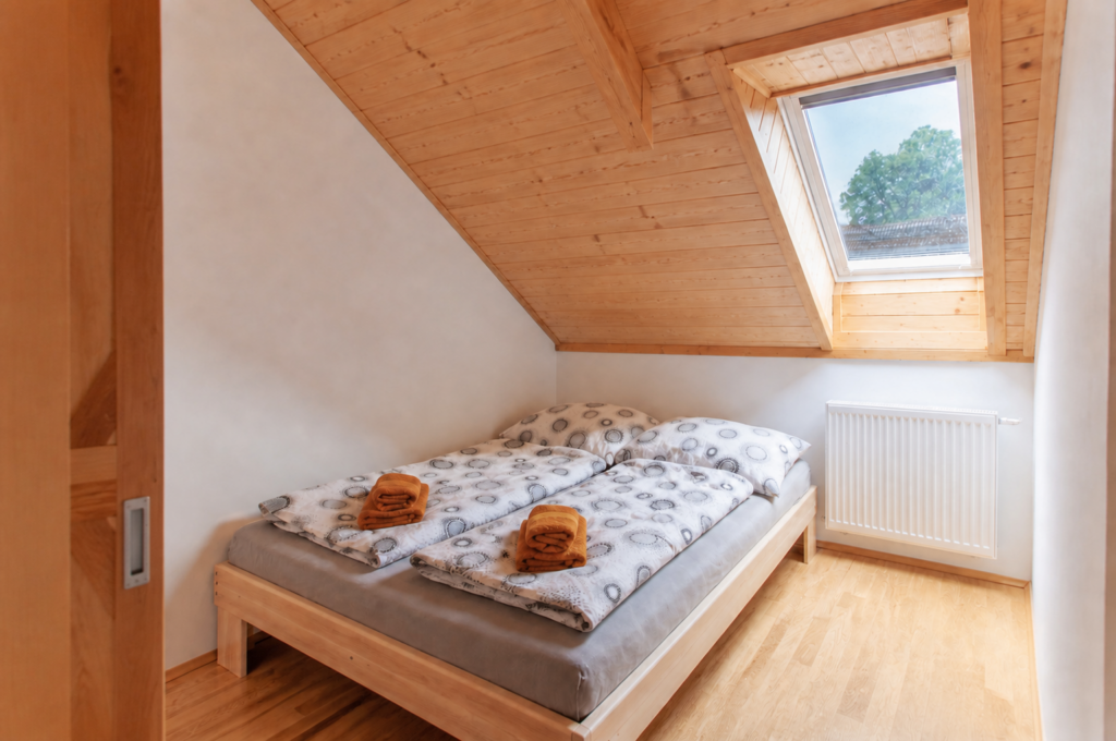 Detail ložnice apartmánu s dřevěným nábytkem